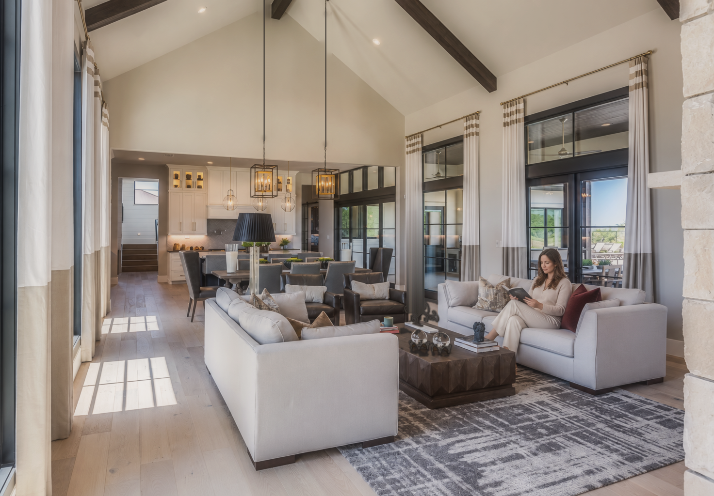 Light-filled great room with a vaulted, wood-beamed ceiling and open kitchen
